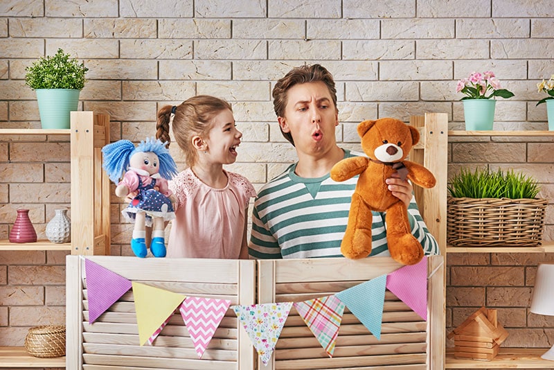 adult and child giving a show with stuffed animals