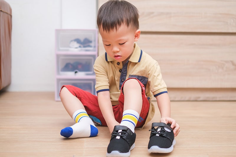 child putting on shoes