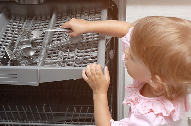 child loading dishwasher