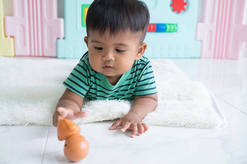 child playing with toy on floor