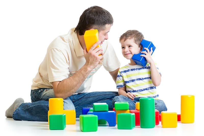 parent and child playing with toy telephones