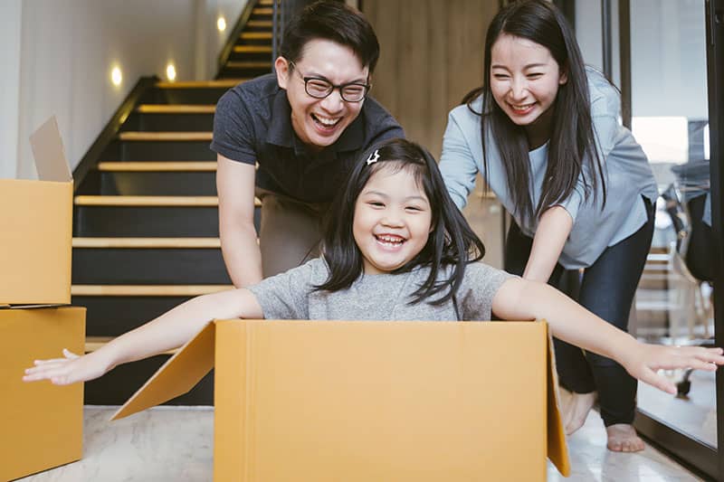 parent pushing a child in a cardboard box