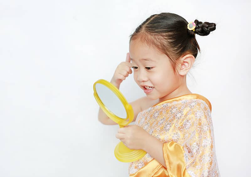 child looking at a mirror